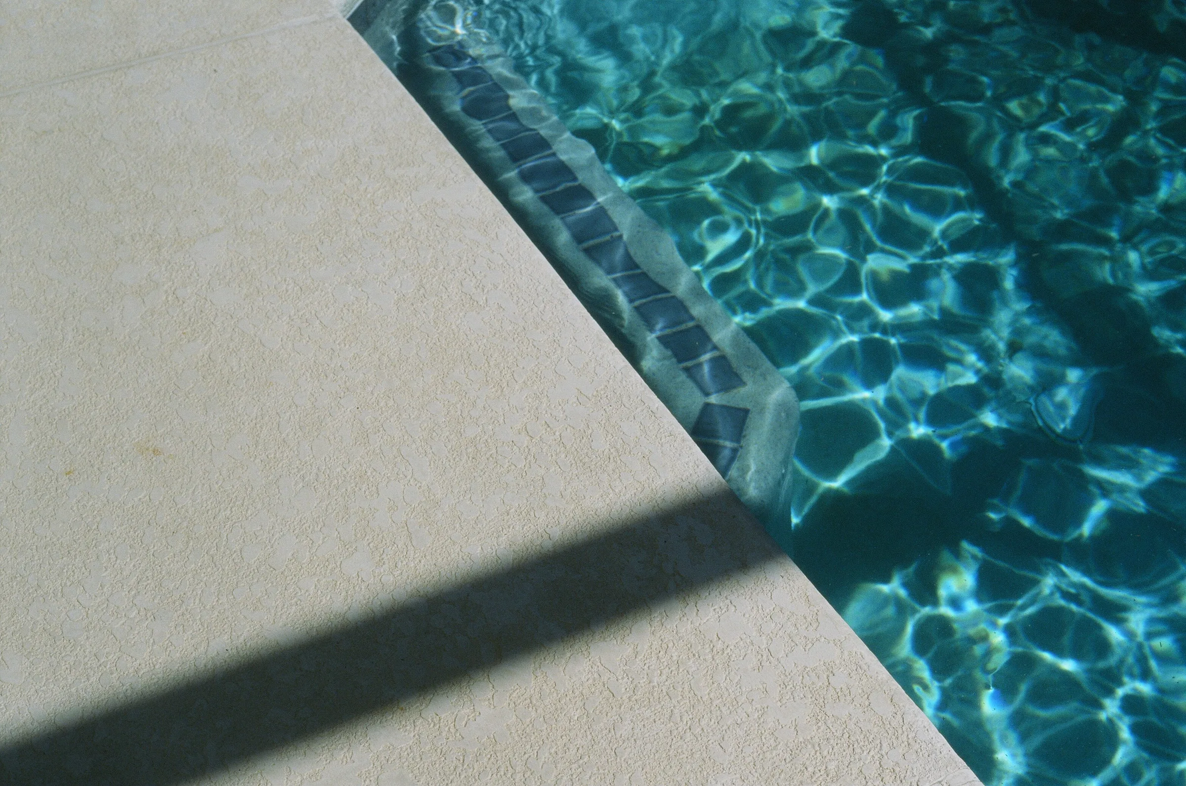 Pool coping, waterline tile and blue water
