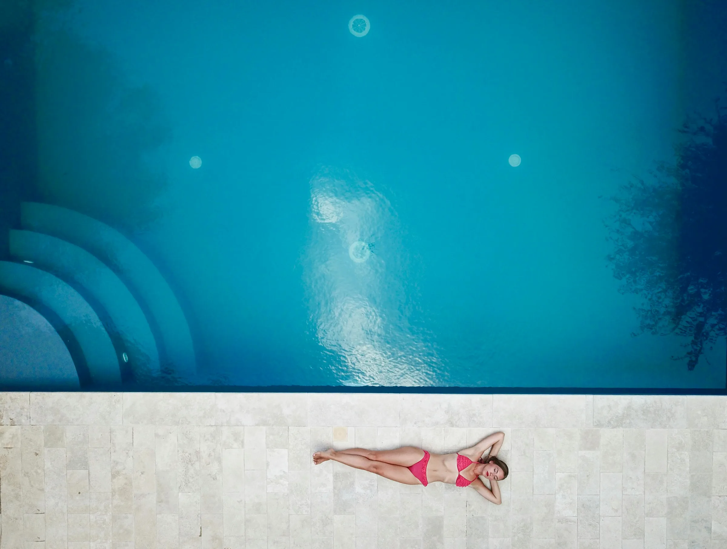 Swimmer viewed from above in a rectangular blue pool